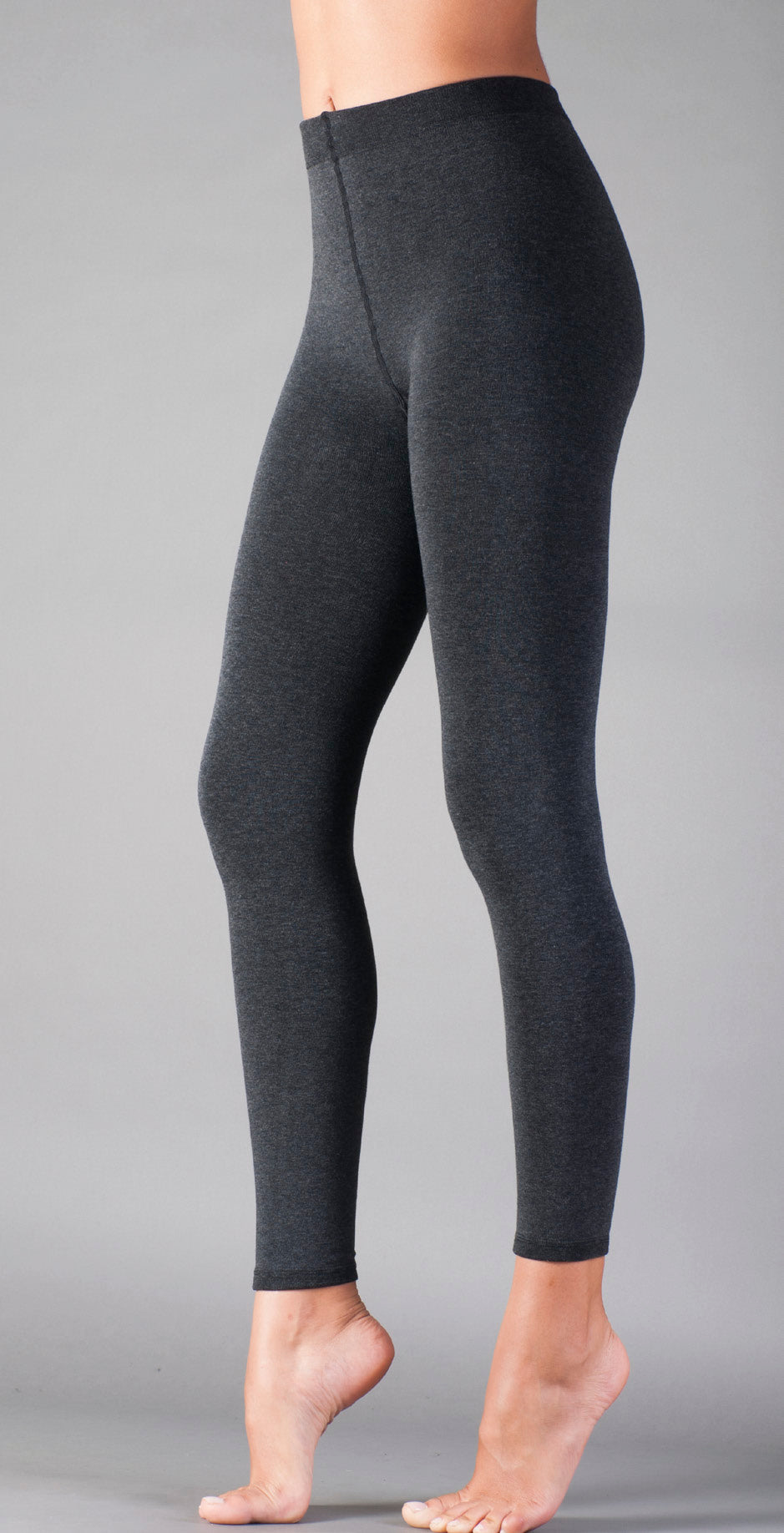 Dark gray leggings worn by a person on a gray background